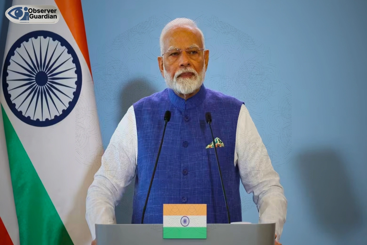 Man speaking at podium with flag. modi